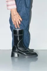 Bota negra de cuero vacuno con tacón de 6 cm y cierre interior.