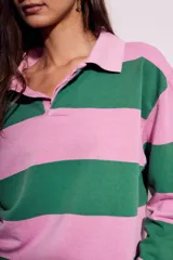 Sweater de algodón peinado a rayas horizontales rosas y verdes, con cuello polo y cierre parcial con botones.