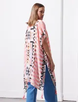 Kimono tejido con estampado abstracto en tonos beige, blanco y negro. Tiene mangas amplias estilo japonés y terminación de ruedo con borlas.