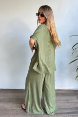 Pantalón tipo palazzo confeccionado en lino color verde militar, con silueta holgada y pierna ancha de caída fluida.