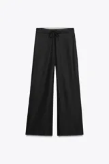Pantalón ancho de tiro medio, confeccionado en hilatura con lino y viscosa. Presenta cintura elástica ajustable con cordones, bolsillos laterales ocultos en costura y pierna ancha.