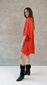 Vestido corto color beige, de raso, con escote en V y mangas 3/4. Corte holgado.