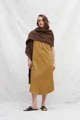 Chal de tejido liviano confeccionado en lana 100% sin teñir, color marrón, con detalle de flecos en los extremos.