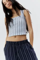 Musculosa blanca con estampado floral celeste, escote cuadrado y ribete de puntilla blanca en cuello y sisas.