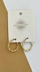 Par de aros tipo argolla dorados con textura trenzada. Cierre a presión. Marca Sacramento.