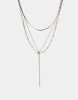 Collar corto plateado de tres capas con diferentes cadenas y nudo metálico.