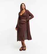 Conjunto de falda midi y cárdigan largo de punto calado color marrón. Incluye un top corto tejido al tono.