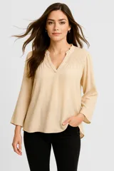 Blusa color beige de viscosa con cuello en V, mangas 3/4 y detalle de broderie en la parte superior.