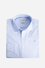 Camisa blanca de manga larga texturizada, tejida en dobby, con cuello italiano y cartera abotonada. Tiene un logo bordado en el pecho.