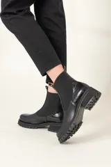 Botas Chelsea de cuero vacuno color negro, con elástico lateral, caña corta y suela track.