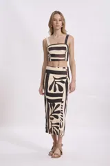 Falda midi color crema con estampado abstracto en tonos marrones y negros, de corte recto y con detalle de botón en la cintura.