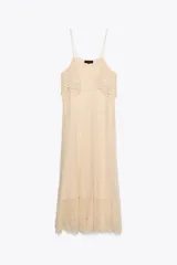 Vestido midi color crema de punto pointelle con tirantes finos y volantes en el escote.