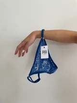 Pack de tres tangas de encaje azul con tiras regulables.