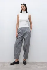 Top sin mangas de tejido canalé en color blanco, con cuello alto tipo tortuga y ajuste al cuerpo.