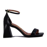 Sandalia de tacón alto color blanco, con una tira delgada sobre los dedos y pulsera con hebilla al tobillo.