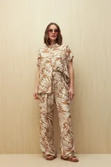 Camisa de manga corta con estampado de hojas en tonos azul y blanco, con botones frontales y puños con vuelta.