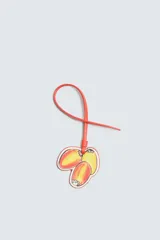 Llavero de cuero con diseño de tres frutas: dos mitades de durazno y una ciruela, con cordón de cuero naranja para colgar. Accesorio de la colección Filipe Jardim x Zara.