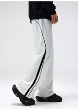 Pantalón deportivo estilo jogging, color verde oliva, con cintura ajustable con cordón y bolsillos laterales. Presenta una franja lateral doble en color blanco.