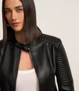 Campera negra de cuero sintético con cuello mao, cierre frontal con cremallera y mangas largas con detalle de pespuntes horizontales.
