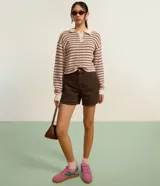 Blusa de manga larga con cuello polo contrastante y botones frontales. Confeccionada en punto texturizado con rayas horizontales en tonos rosa, marrón y crema.