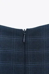 Mono corto azul con estampado de cuadros, cuello redondo, sin mangas y abertura en el bajo delantero. Cierre trasero con cremallera.