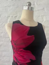 Vestido corto negro con estampado de flores rojas, confeccionado en microtul forrado.