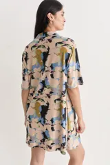 Vestido camisero corto con estampado abstracto, cuello camisero, mangas cortas y cierre frontal con botones.