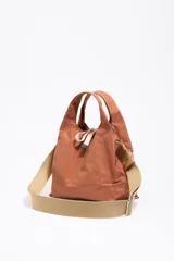 Bolso de mano negro de nailon con estructura blanda, doble asa de mano y asa de tejido regulable. Cuenta con logo metálico BIMBA Y LOLA, acabados metálicos, bolsillo interior, cierre de cordón e interior con etiqueta de tejido.