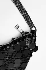 Cartera plateada con lentejuelas y cadena metálica.