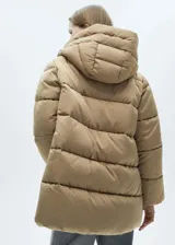 Campera puffer larga color beige, con capucha, cierre frontal con cremallera y bolsillos laterales con cierre.