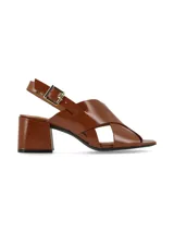 Sandalias negras de charol con tiras cruzadas, tacón cuadrado y pulsera al tobillo con hebilla metálica.