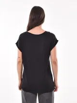 Remera blanca de corte holgado con cuello en V y mangas cortas con dobladillo. 