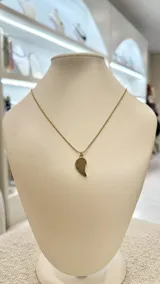 Collar dorado con cadena de eslabones finos y dije en forma de ala.
