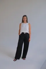 Pantalón negro de corte sastrero confeccionado en lino italiano, de pierna ancha y tiro alto. Incluye cinturón trenzado con hebilla redonda.