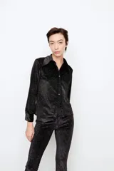 Camisa negra de punto con diseño de rayas diagonales en lurex, calce slim, cuello alargado, apertura en cartera delantera con botones negros y pinzas traseras.