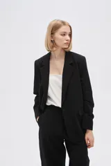 Blazer blanco de viscosa, con cuello solapa, bolsillos frontales y cierre con botón.