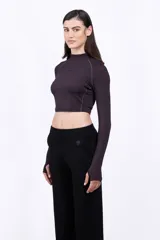 Camiseta cropped ceñida de color negro, con cuello alto y mangas largas.