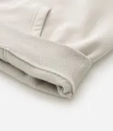 Saco con capucha color beige, con cordón ajustable, bolsillo canguro, mangas largas y barras ajustadas. Confeccionado en algodón con felpa, de corte comfort.