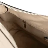 Bandolera color hueso de cuero sintético graneado, con formato rectangular y correa regulable. Tiene acceso con cierre, un bolsillo interno con cierre y otro abierto. El interior es de tela de algodón y poliéster, y los herrajes son plateados.