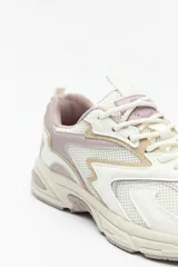 Zapatillas urbanas blancas con detalles plateados, de caña baja y cordones.