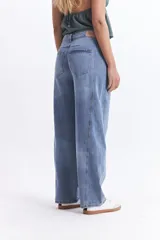 Pantalón jean celeste de tiro medio, corte amplio y redondeado.