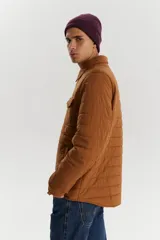 Campera marrón acolchada con cuello camisero, cierre frontal con botones a presión, dos bolsillos de parche en el pecho con solapa y dos bolsillos laterales.