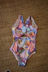 Traje de baño enterizo con estampado abstracto multicolor, escote en V y abertura en la zona abdominal.