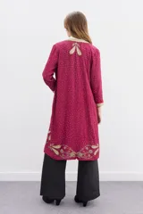 Saco largo de viscosa color fucsia con bordados dorados. Presenta un diseño con guarda bordada en el delantero, escote y puños, cuello redondo y cierre frontal con ganchos invisibles.