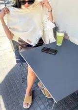 Bufanda rectangular color crudo, tejida en lana merino con flecos en los bordes.