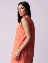 Vestido de algodón texturado color naranja, con cuello en V y sin mangas.