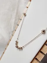 Cadena enchapada en oro con cinco perlas distribuidas a lo largo de su diseño.