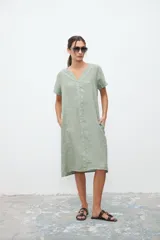 Vestido midi verde claro de lino, corte recto, cuello en V y mangas cortas.