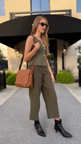 Bandolera de hombro color gris claro, con solapa frontal y correa ajustable. Presenta un diseño simple y práctico, ideal para uso diario.