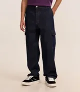 Pantalón de jean azul oscuro, modelo baggy, con bolsillos cargo laterales y cintura con trabillas.